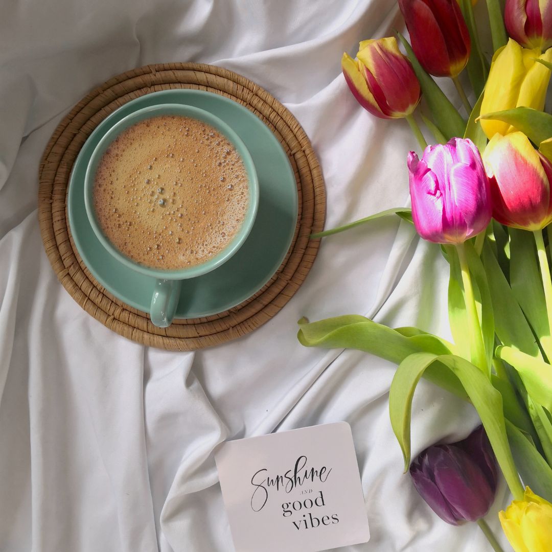 a cup of gratitude ritual superfood blend next to flowers with a note saying sunshine and good vibes